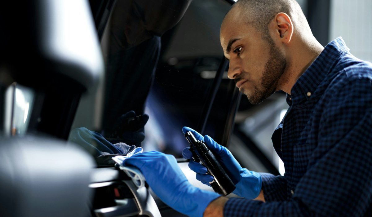 African American man car service worker applying nano coating on a car